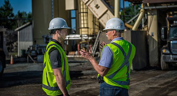 Two workers speaking on worksite